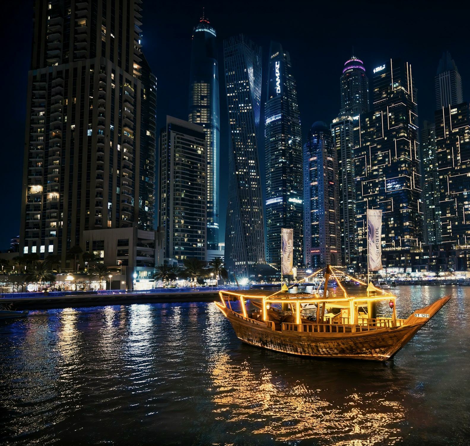Illuminated dhow cruising through Dubai Marina at night
